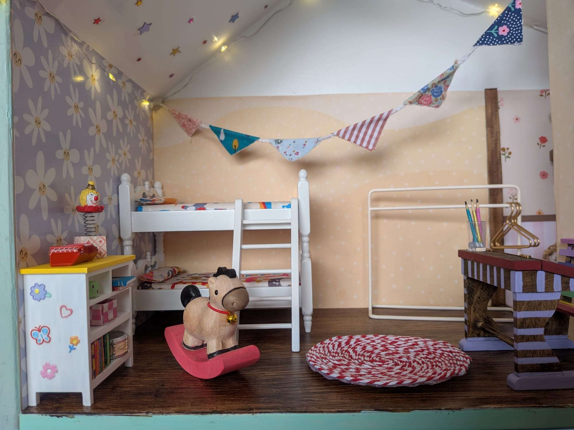 Quarto em miniatura com beliche, brinquedos e secretária